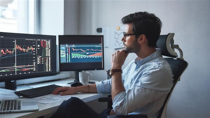 Trader analyzing charts on screen