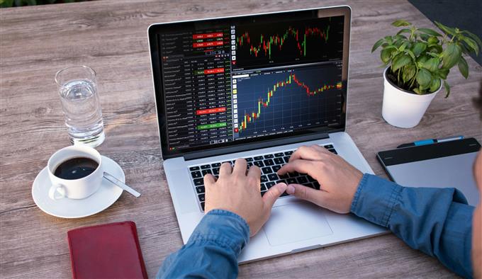 Trader viewing forex charts on a laptop