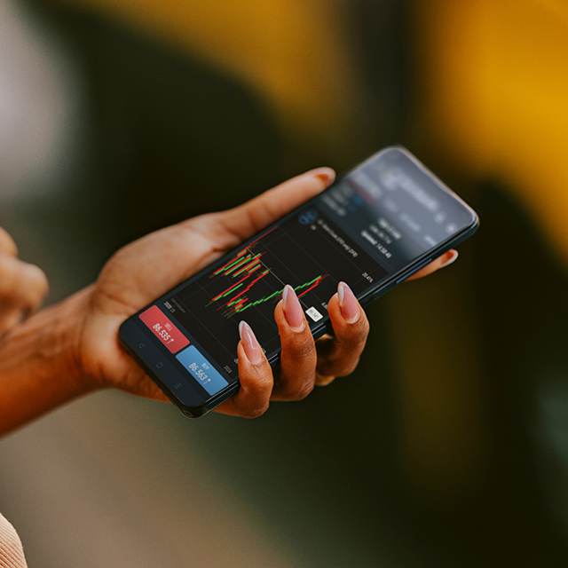 Phone in hand showing trading