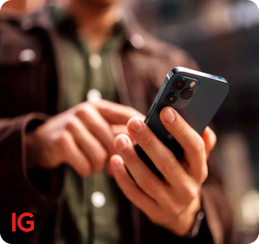 Personne tenant un smartphone noir avec l'application IG ouverte, l'écran visible dans ses mains