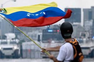 personne tenant un drapeau du Venezuela