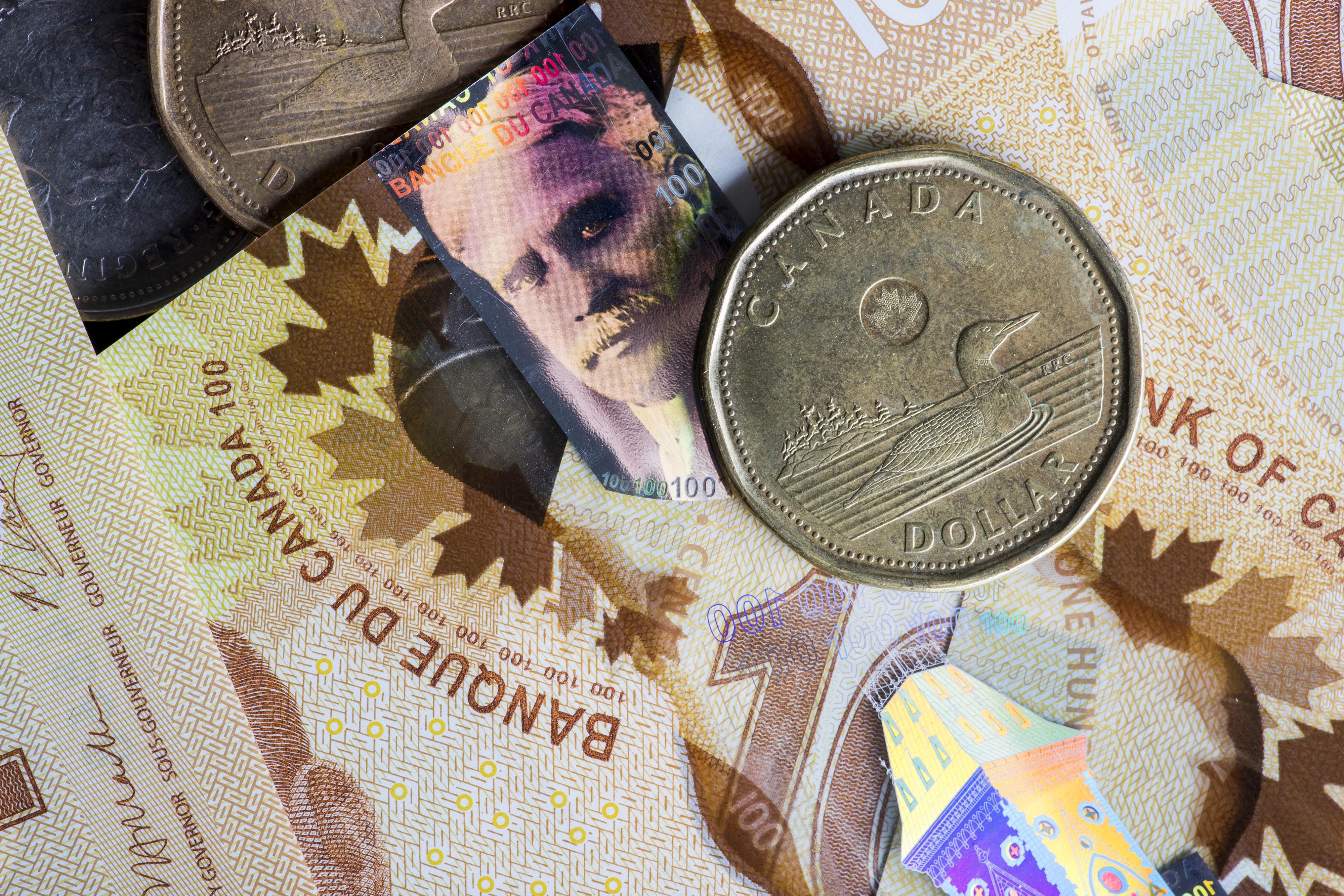 Image of Canadian dollar on background of Canadian flag