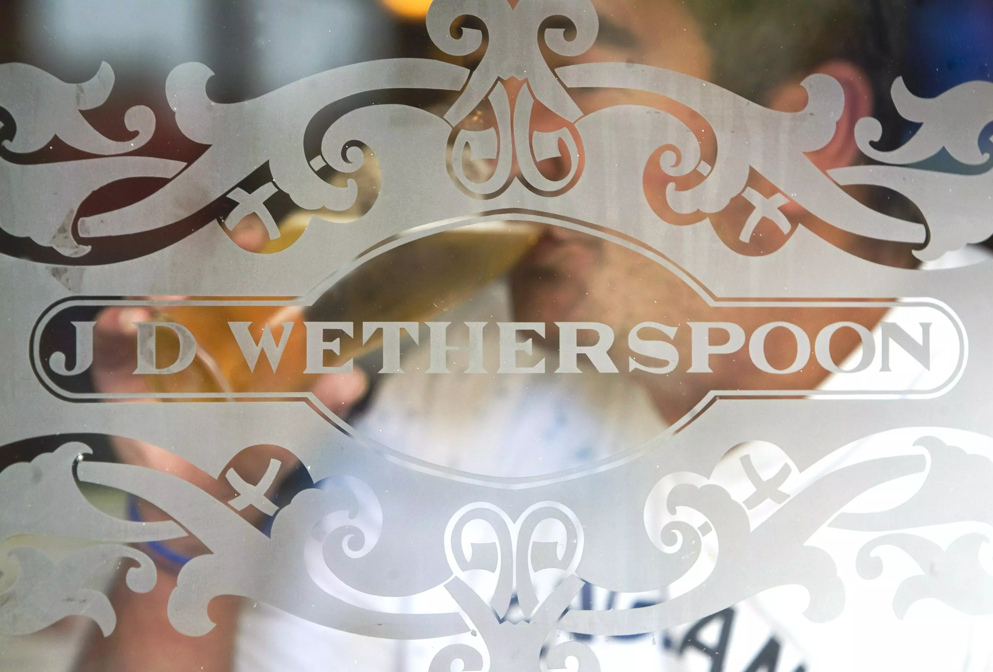 Image of the J D Wetherspoon logo on a glass window.
