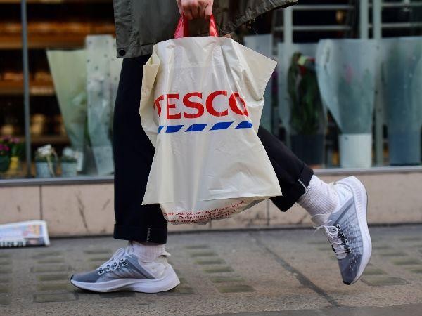 Person carrying a Tesco shopping bag